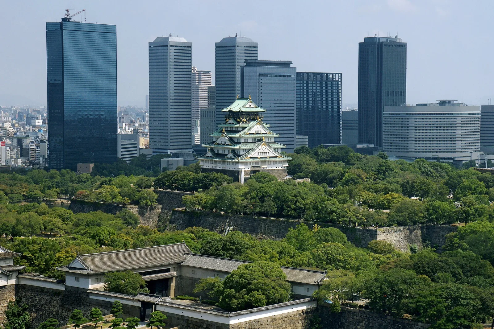 Osaka Castle rising above its stone walls and surrounding greenery